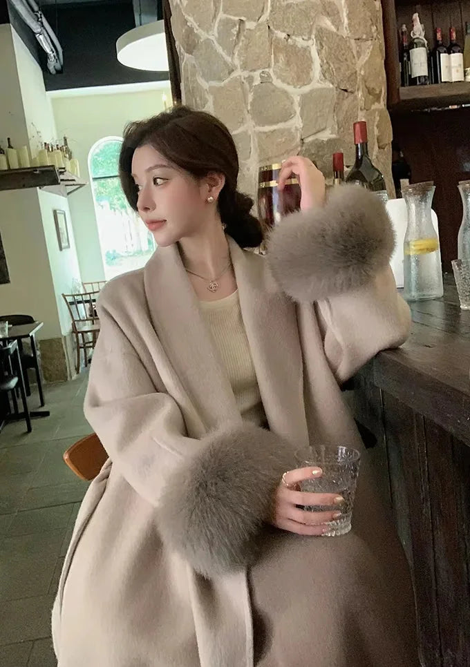 Long belted women's coat with faux fur sleeves