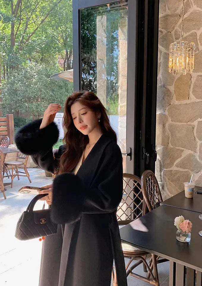 Long belted women's coat with faux fur sleeves